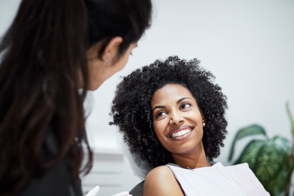 dentist talking to patient in chair