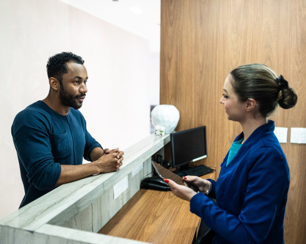man waiting at dental frontdesk