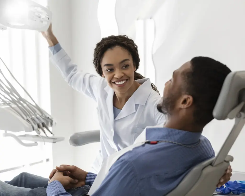 Dentist shining light on the teeth of a patient lying down in dentist chair